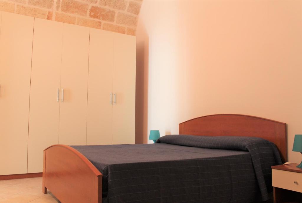 a bedroom with a bed and white cabinets at Dimora Nonna Sisina in Polignano a Mare