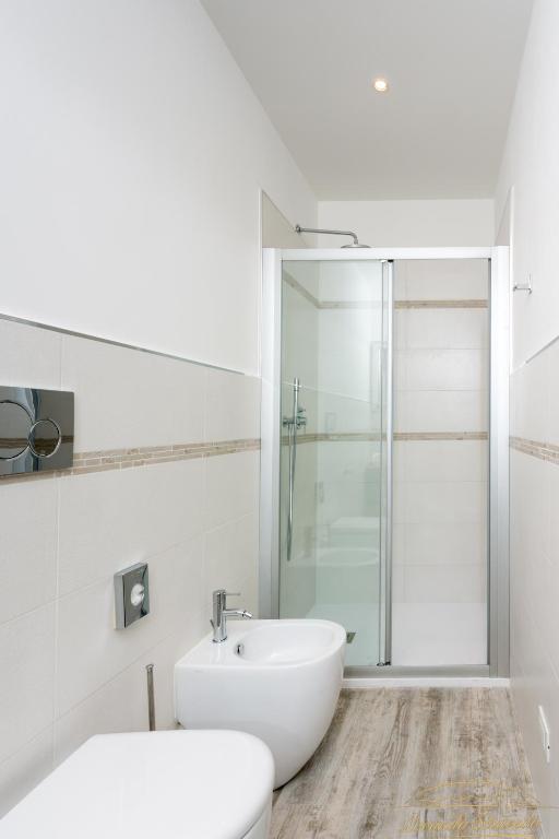 a white bathroom with a sink and a shower at Locanda Stravedo in Pellestrina