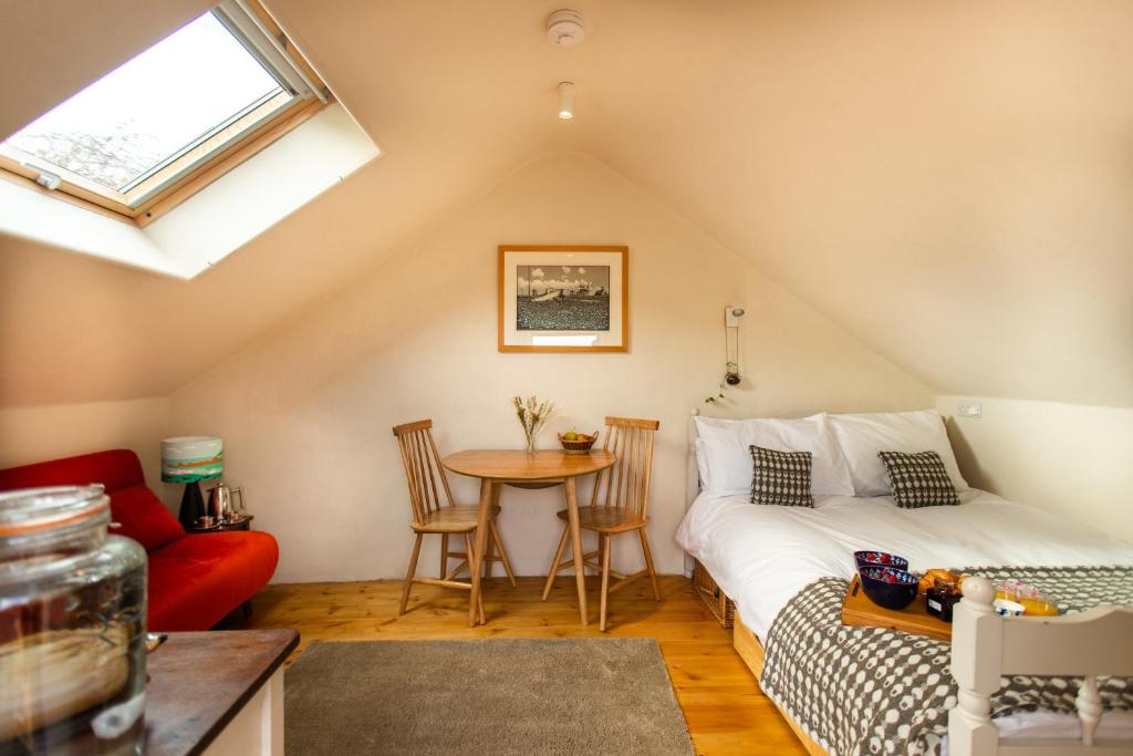 a attic room with a bed and a table at Snowdonia Hideaway in Tywyn