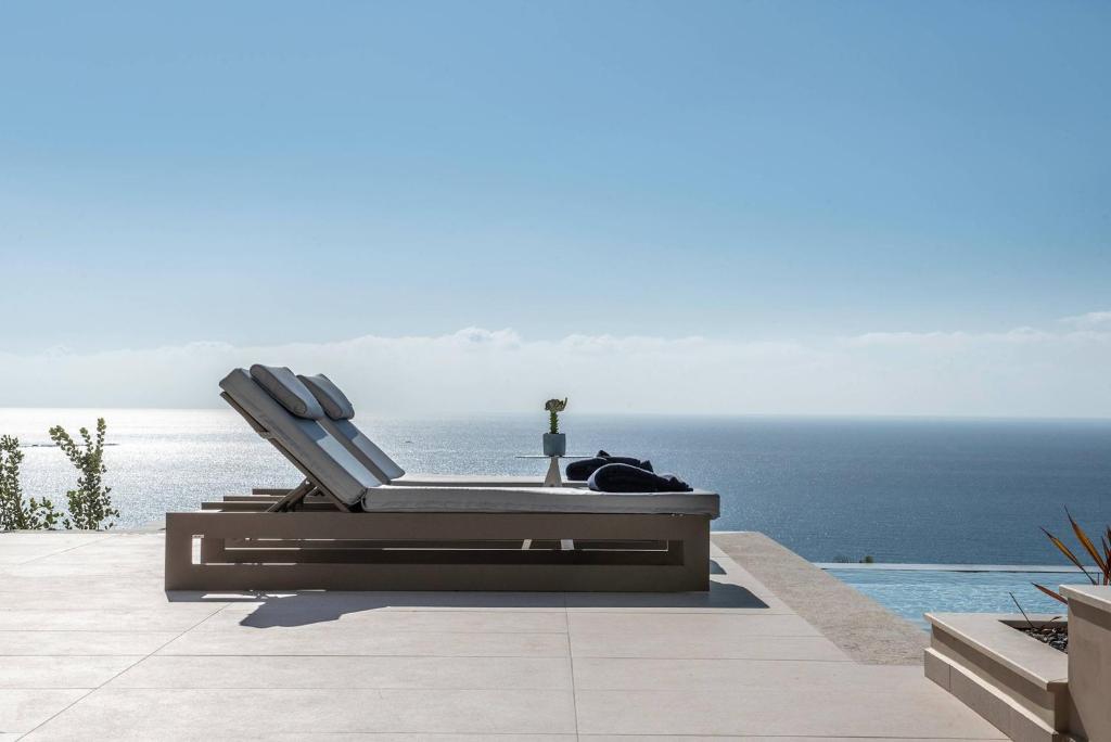 a pair of chairs sitting next to a swimming pool at Cielo e Mare Villas in Falasarna