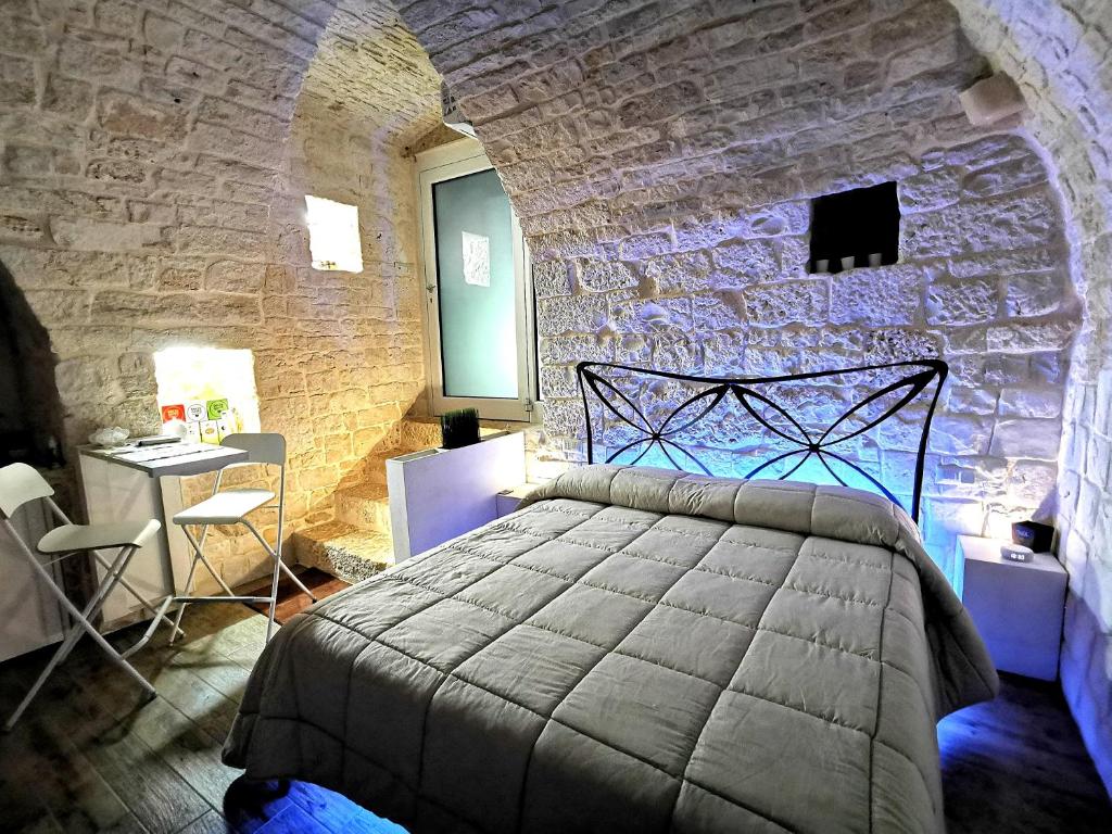 a bedroom with a large bed in a stone wall at Trully in Alberobello