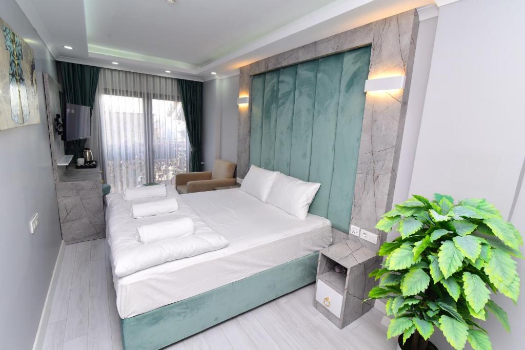 Little sofia hotel في إسطنبول: غرفة نوم صغيرة بسرير ابيض ومصنع