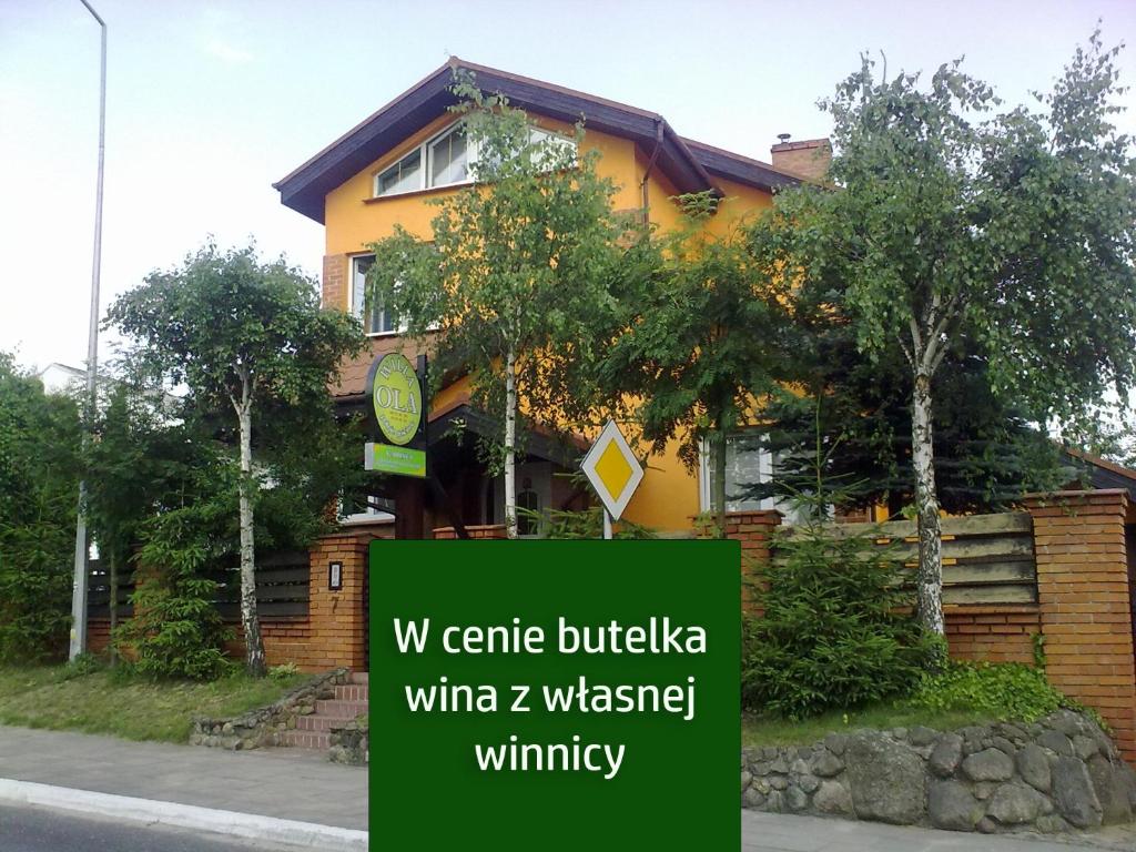 ein gelbes Haus mit einem Schild davor in der Unterkunft Agroturystyka Willa Ola in Giewartów