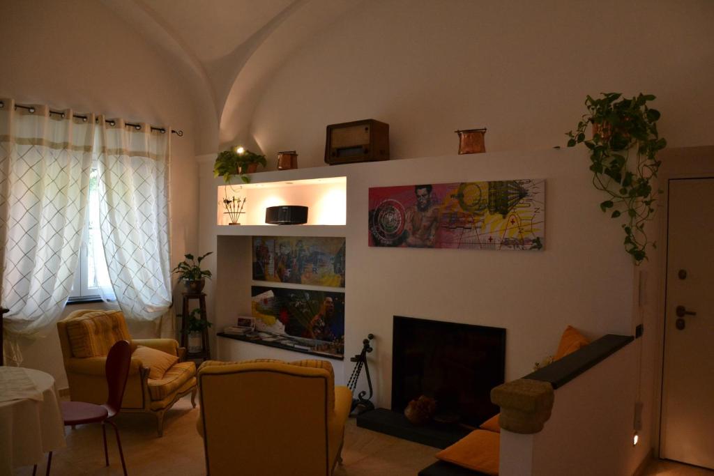 a living room with a fireplace and some chairs at B&B Torre Porta Marina in Ventimiglia