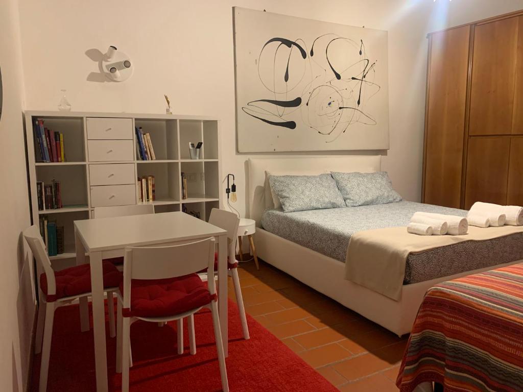 una camera con letto, scrivania e tavolo di La casa del Centro a Modena