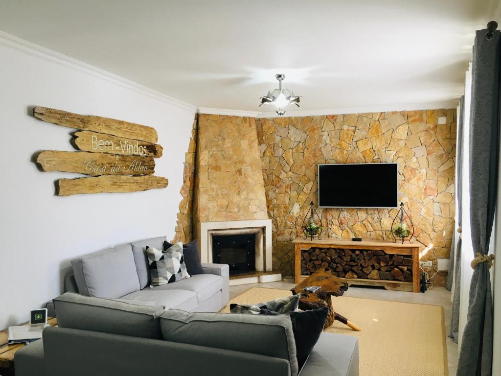 ein Wohnzimmer mit einem Sofa und einem Kamin in der Unterkunft Casa da Aldeia in Tomar