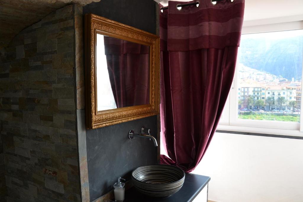 a bathroom with a sink and a mirror and a window at B&B Torre Porta Marina in Ventimiglia