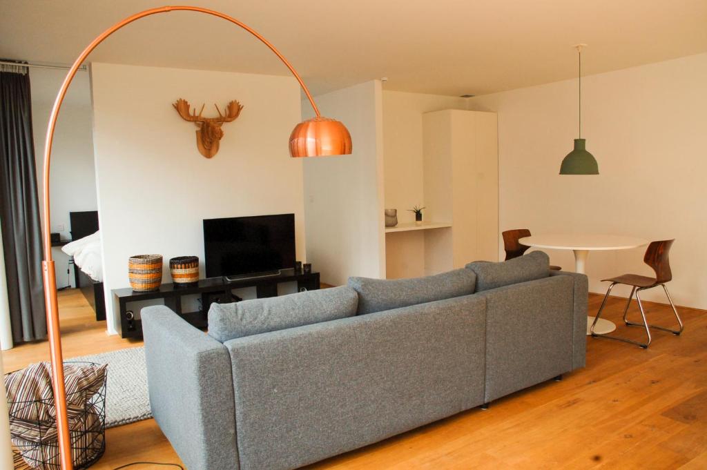 sala de estar con sofá azul y mesa en ROOOm Kortrijk, en Cortrique