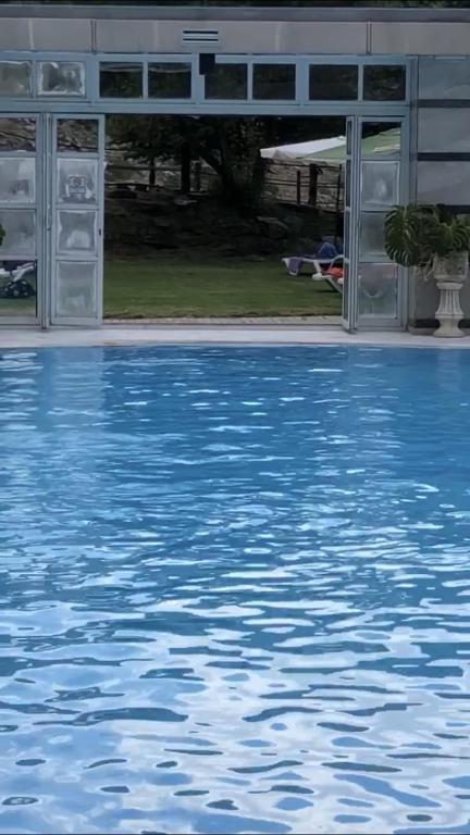 duży basen z niebieską wodą przed budynkiem w obiekcie Exclusivo DÚPLEX en la PLAZA w mieście Sierra Nevada
