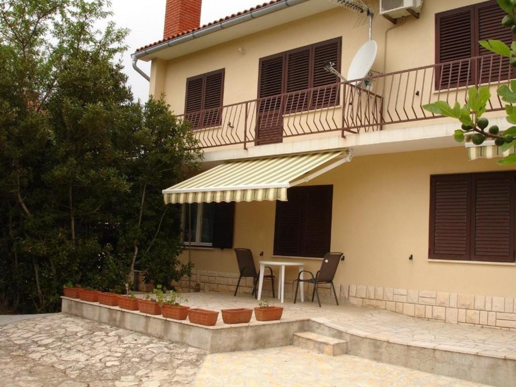 a house with a table and a balcony at Apartments Deželić in Cres