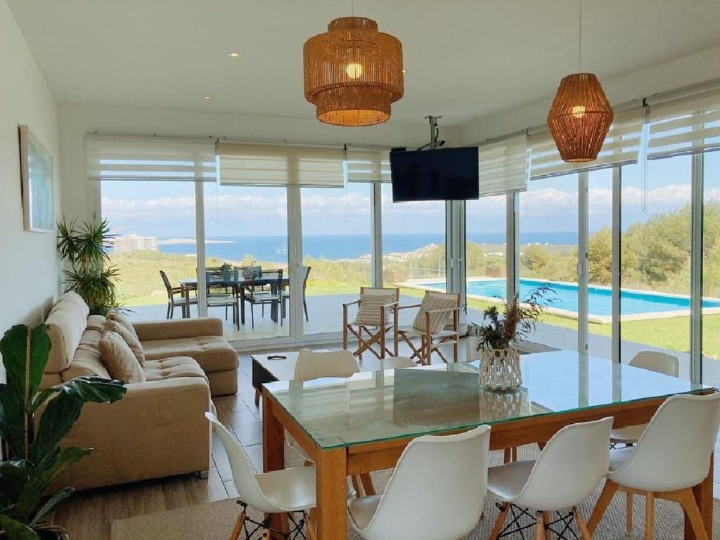 a living room with a table and chairs and a pool at Villa Bella in Es Mercadal