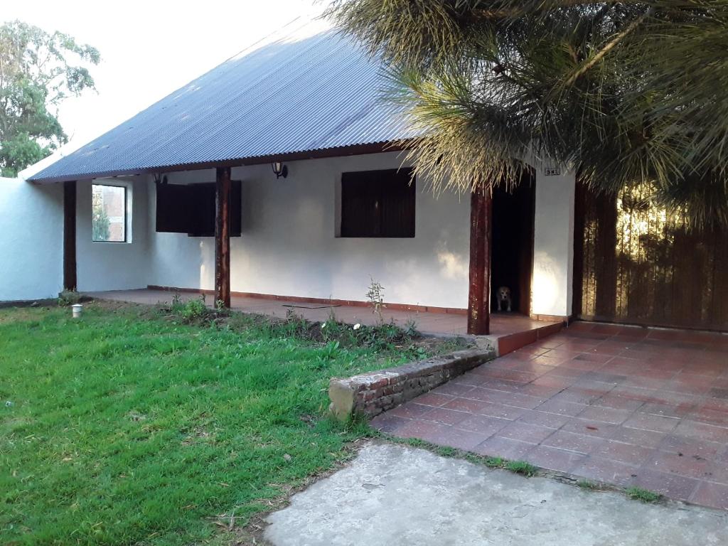 a white house with a palm tree in front of it at Estilo Campo Casa de 3 ambientes cochera interna in Mar del Plata
