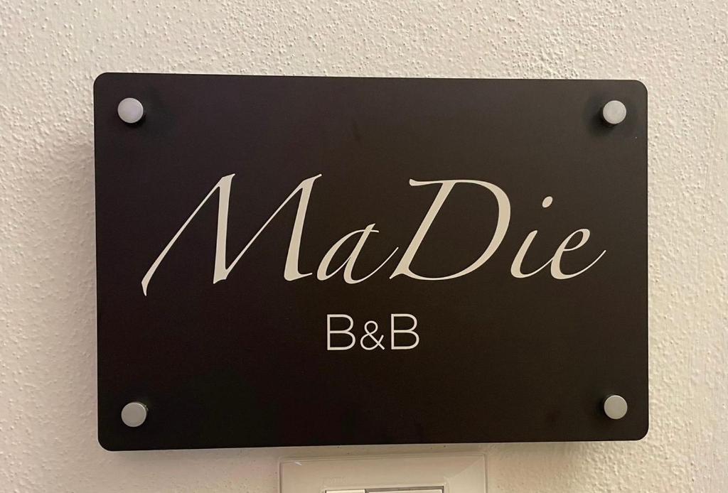 un segno che legge maldice bcb su un muro di B&B MaDie a Castelsardo