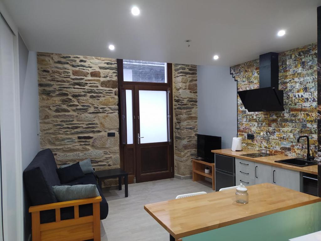a kitchen and living room with a stone wall at Paloma blanca in Villalba