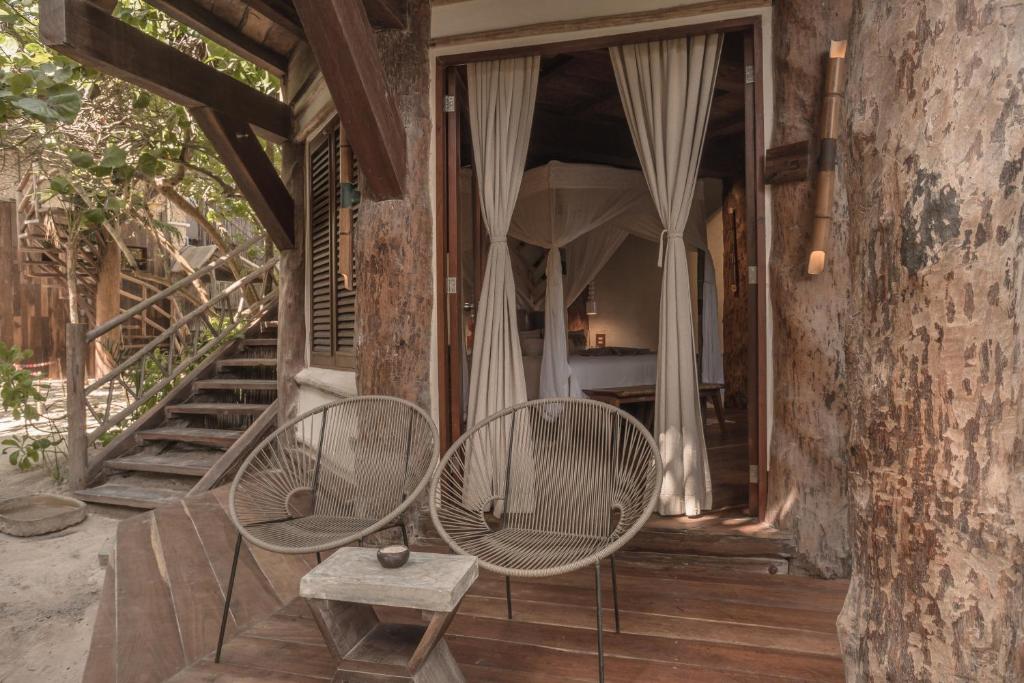 two chairs and a table on a porch at Delek Tulum in Tulum