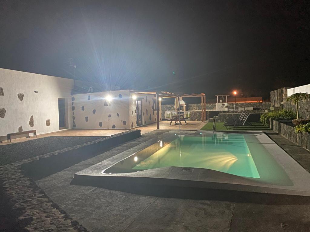 una casa con piscina por la noche en Rosa de la laguna, en Lajares