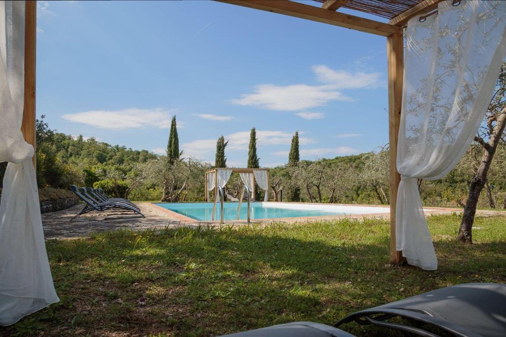 a view of a swimming pool from the yard of a house at Le Logge in Pergine Valdarno