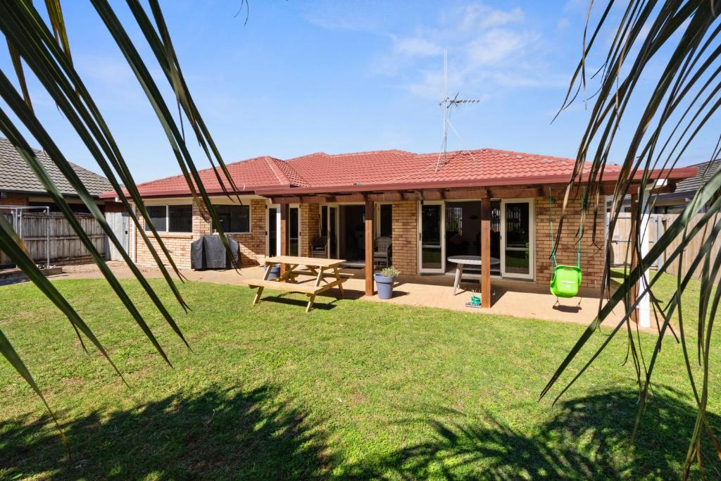 a house with a picnic table in the yard at Mount Holidaze - Mt Maunganui Holiday Home in Matapihi