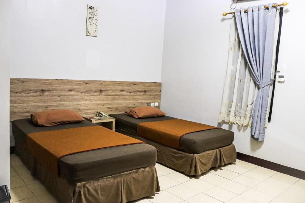 Postel nebo postele na pokoji v ubytování Hotel Pesona Merak