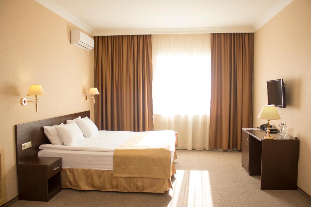 une chambre d'hôtel avec un lit et une fenêtre dans l'établissement Hotel Aner, à Astana