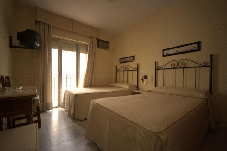 pokój hotelowy z dwoma łóżkami i oknem w obiekcie Hostal El Labrador w Marbelli