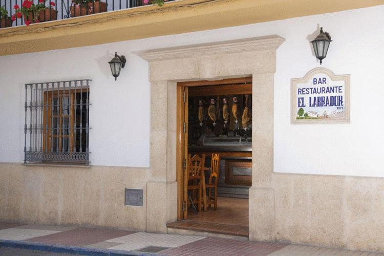 un edificio con puerta a un bar con botellas de vino en Hostal El Labrador, en Marbella