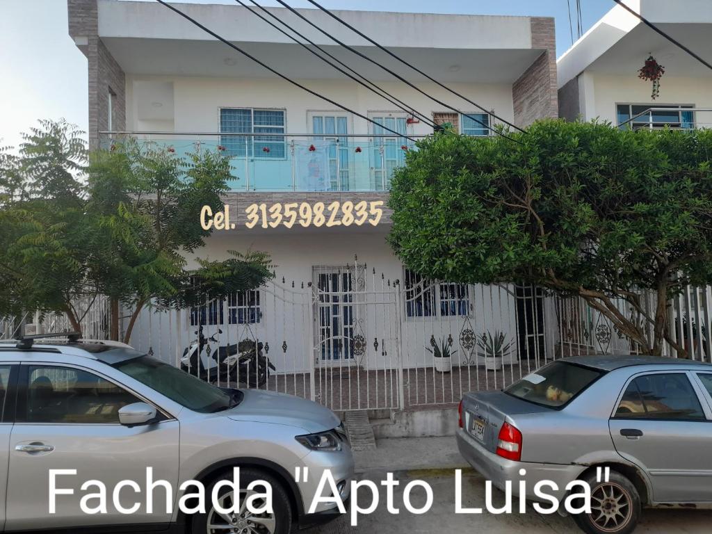 twee auto's geparkeerd voor een gebouw bij Apartamentos LUISA in Coveñas