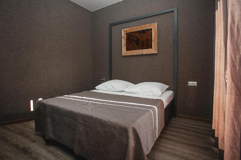 a bedroom with a bed with a painting on the wall at ESENIN-LocuS in Novosibirsk