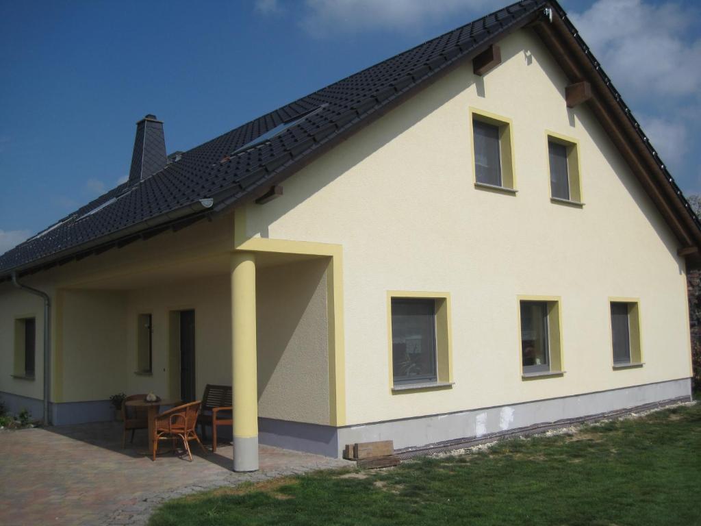 een groot wit huis met een patio bij Haus am Park in Thallwitz