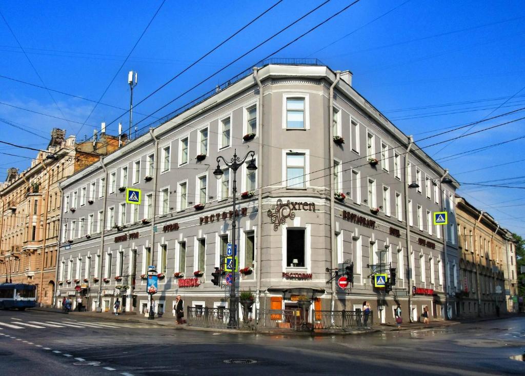 a large white building on the corner of a street at 5th Corner Hotel in Saint Petersburg