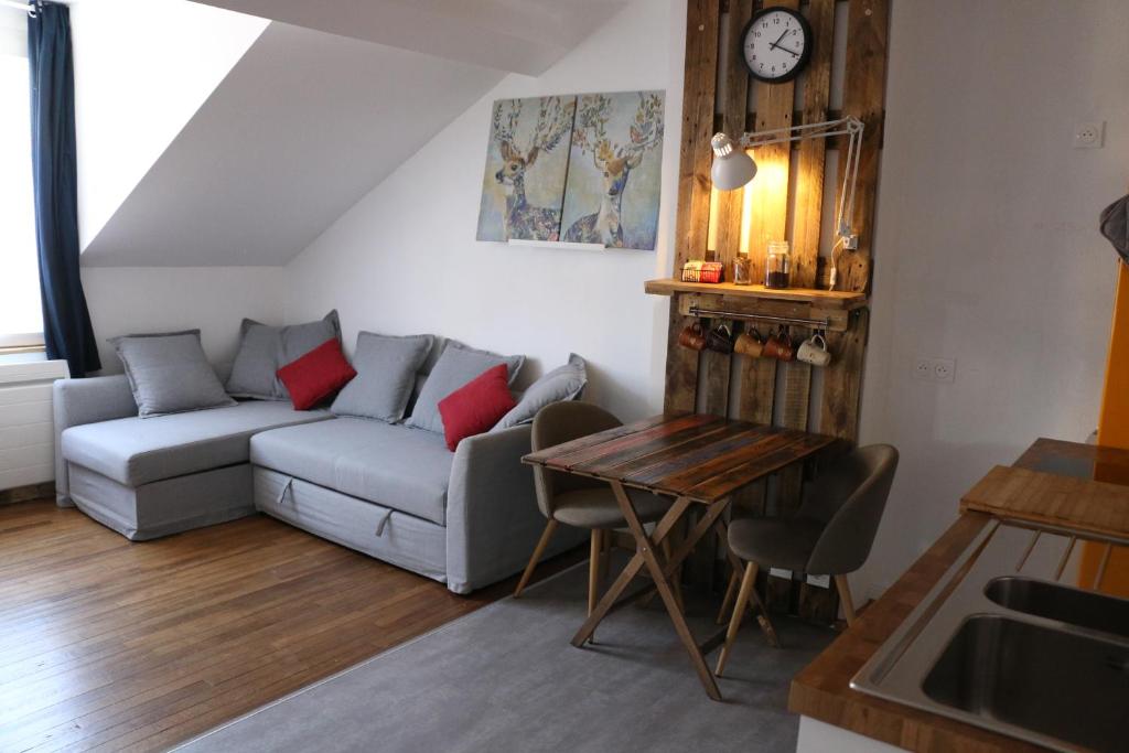 ein Wohnzimmer mit einem Sofa und einem Tisch in der Unterkunft Le Studio de Sophie in Vendôme