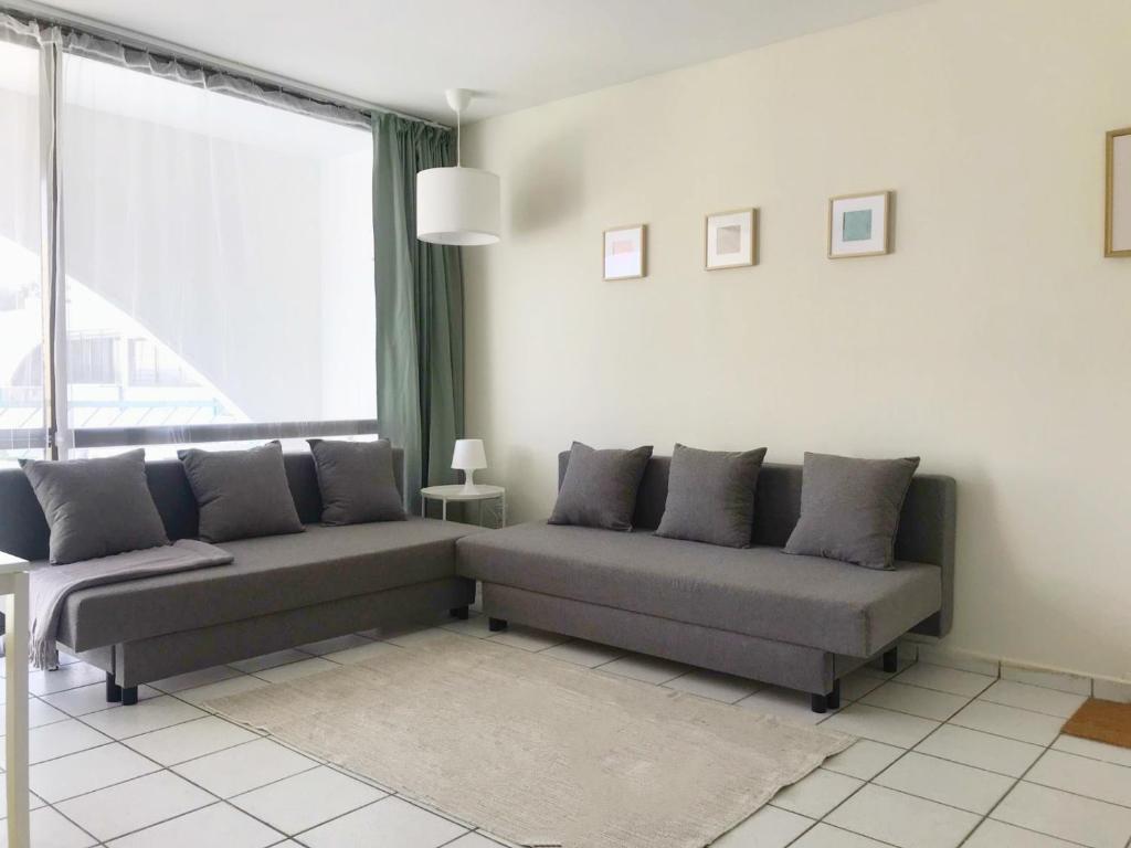 uma sala de estar com dois sofás e uma grande janela em Apartament - Lev Eilat 8 em Eilat