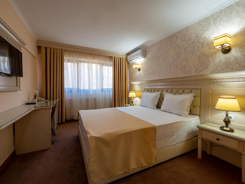 a hotel room with a large bed and a window at Hotel Orient Galati in Galaţi