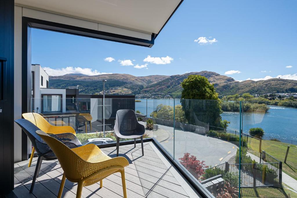 a balcony with chairs and a view of the water at Homestead Retreat - 2 Bedroom - Lake View in Queenstown