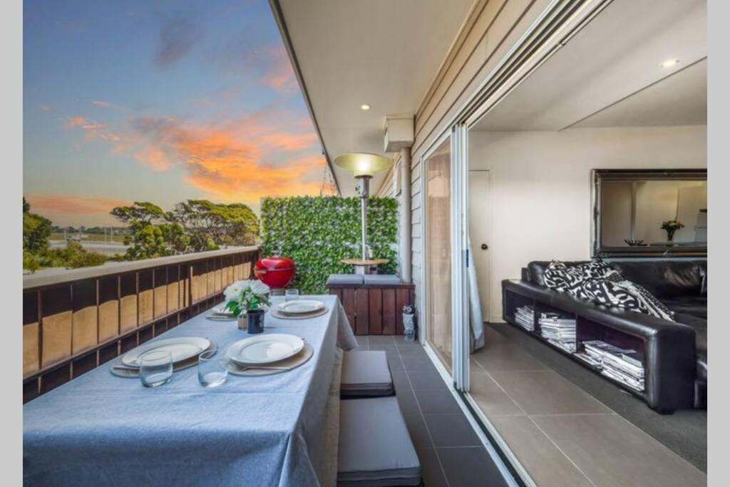 a room with a table on a balcony at Modern 3 bedroom apartment, beach, surf & shops in Cape Woolamai