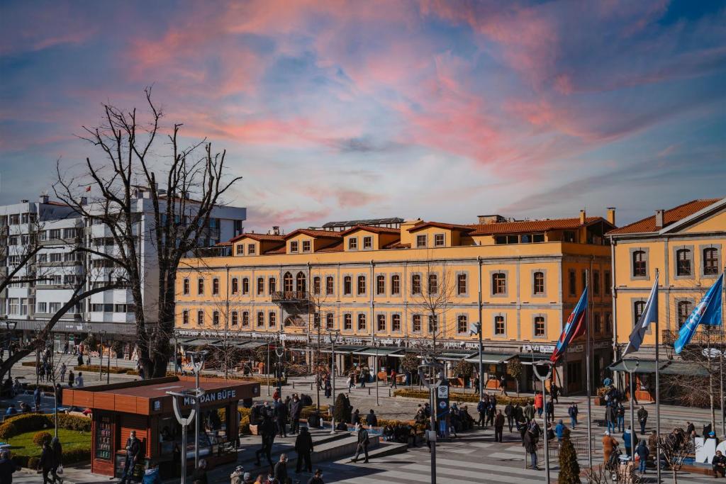 een groep mensen die in een stad wandelen met een gebouw bij TS Park Hotel in Trabzon