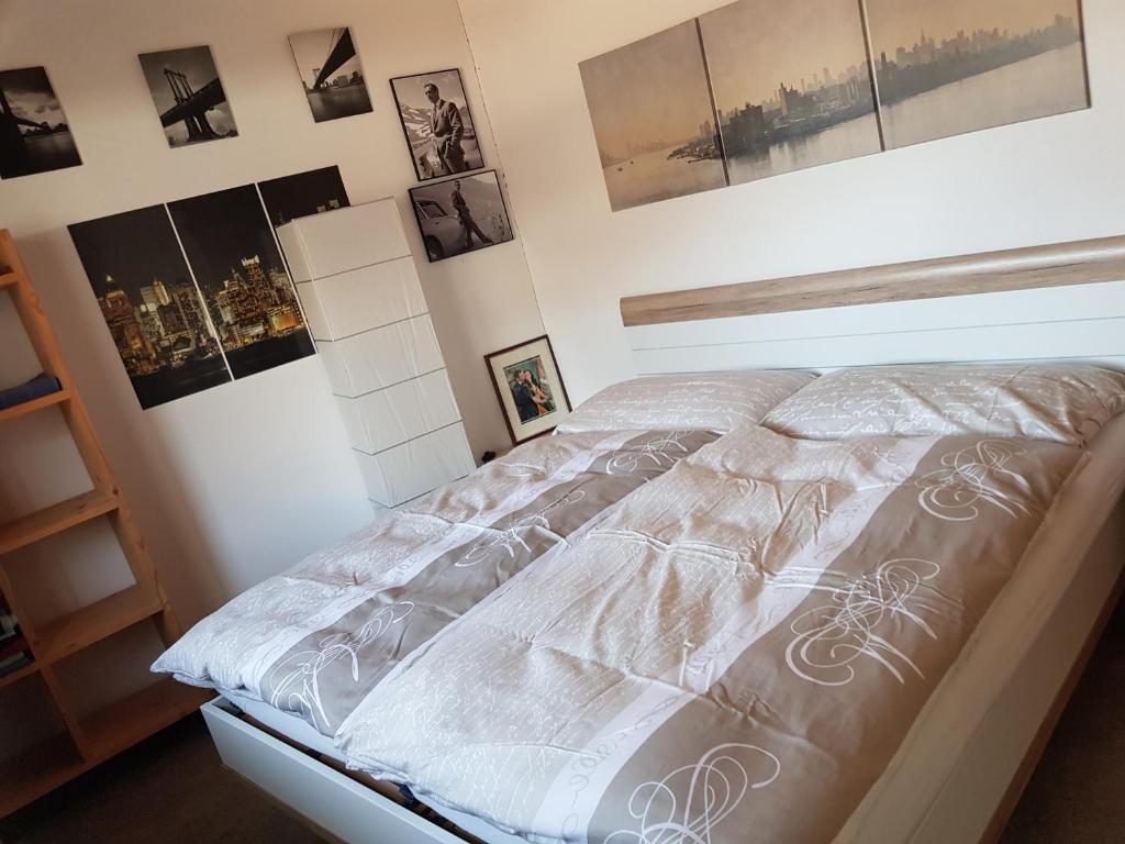 1 cama en un dormitorio con cuadros en la pared en Neuwertige 3 ½ Zimmer-Wohnung in Zillis/Andeer, en Zillis