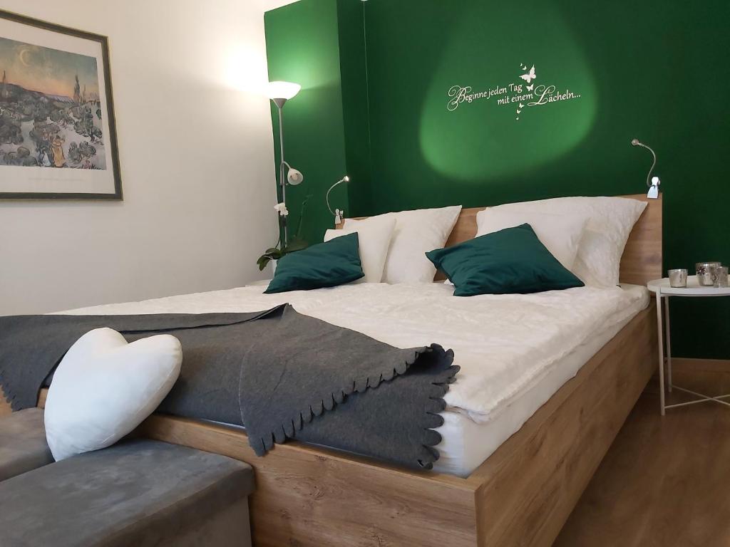 um quarto com uma cama de madeira e uma parede verde em Ferienwohnung Sonne em Waidhofen an der Ybbs