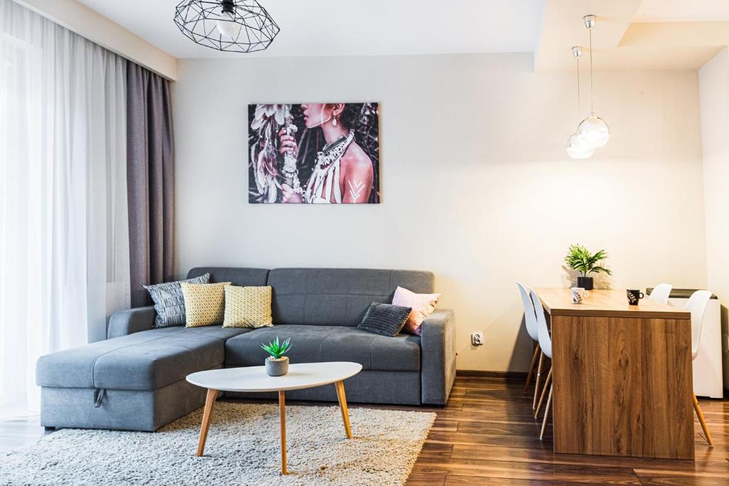 uma sala de estar com um sofá azul e uma mesa em Bulwar Apartament em Glogóvia