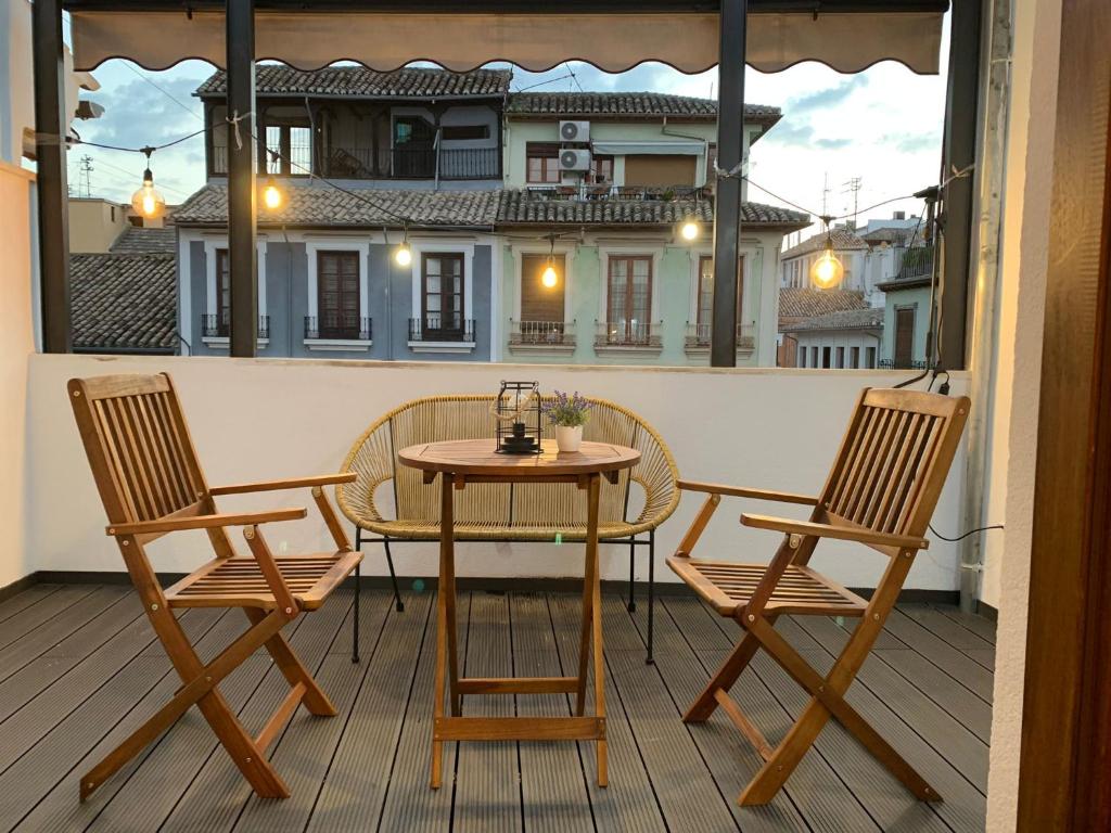 a table and two chairs on a balcony at ECO CENTER GRANATENSIS (ÁTICO-CATEDRAL) in Granada