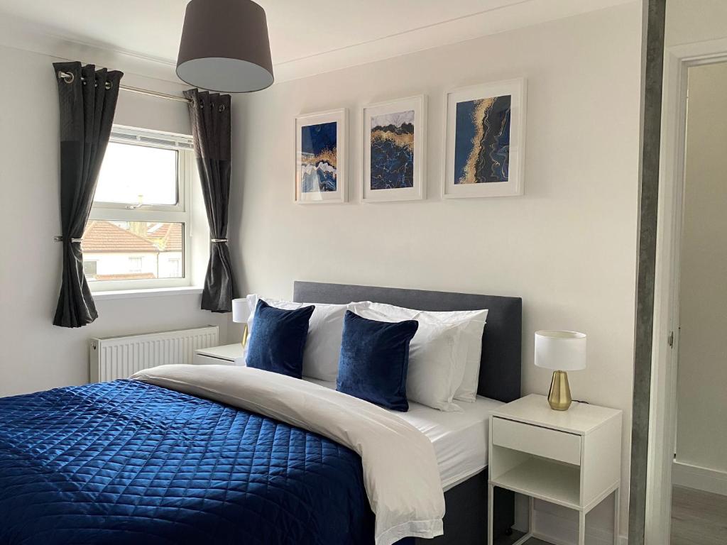 Un dormitorio con una cama azul y blanca y una ventana en Saffron Court by Wycombe Apartments - Apt 12, en High Wycombe