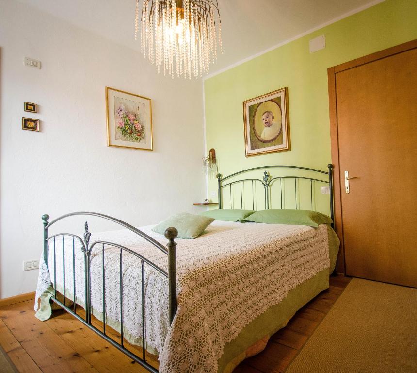 a bedroom with a bed and a chandelier at B&B Marie Therese in Torreano