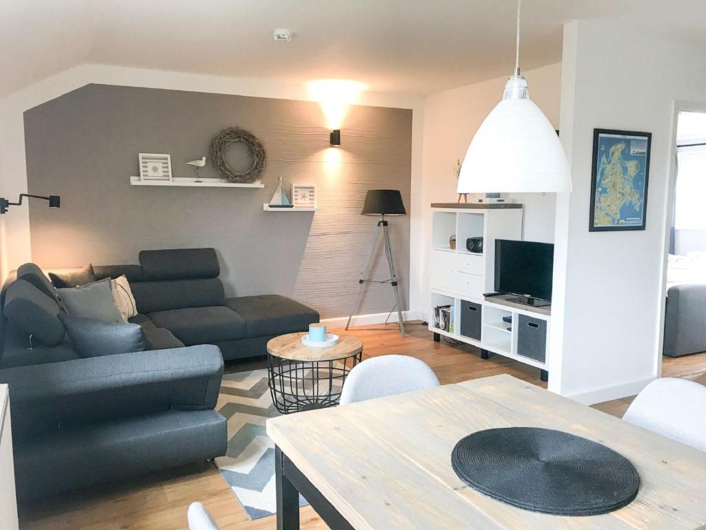 a living room with a couch and a table at Feriendorf Rugana - Komfortplus Appartement mit 1 Schlafzimmer A03 in Dranske