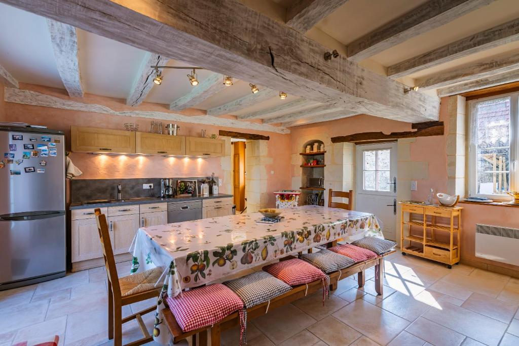 a kitchen with a table with chairs and a refrigerator at Longère PROCHE LOCHES in Ciran