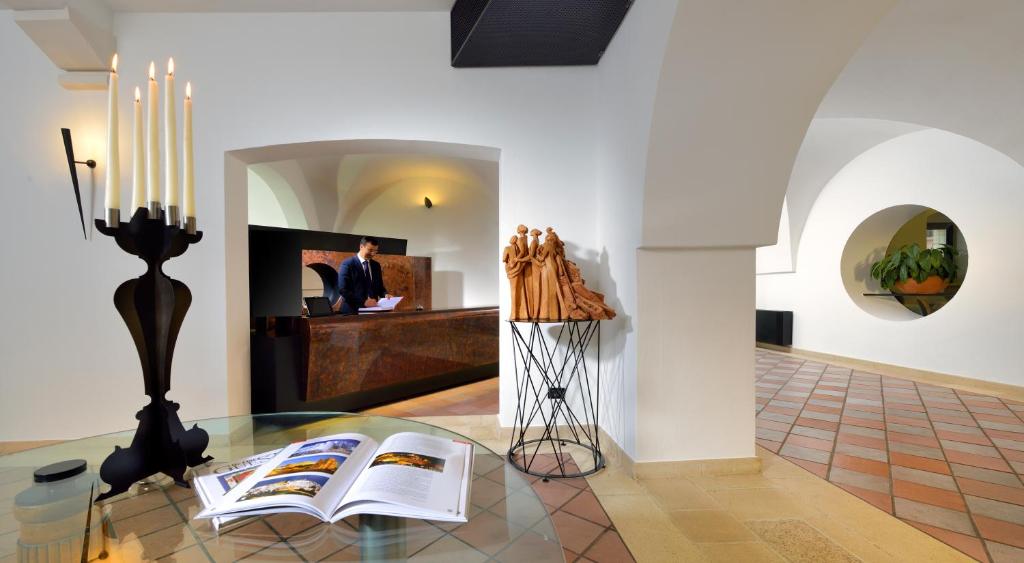 a room with a table with a book and a fireplace at Grand Hotel Masseria Santa Lucia in Ostuni