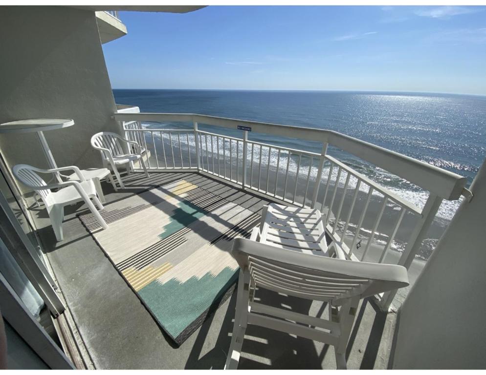 a balcony with chairs and a view of the ocean at 1108 Waters Edge Resort condo in Myrtle Beach