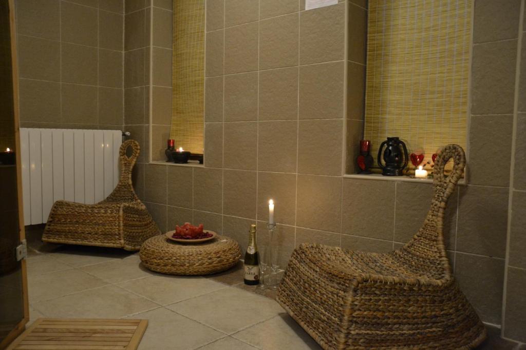 a bathroom with two wicker chairs and a candle at Hotel Condor in Drobeta-Turnu Severin