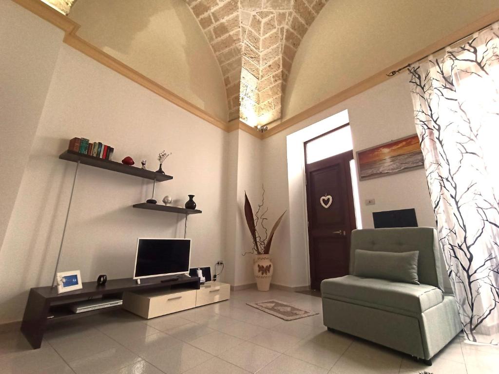 ein Wohnzimmer mit einem Stuhl und einem TV in der Unterkunft Casa Amata Salentina in Squinzano