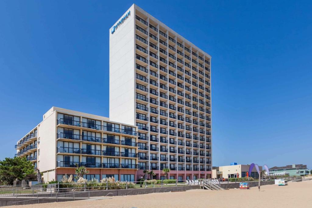 Un edificio alto con un cartel al costado. en Wyndham Virginia Beach Oceanfront, en Virginia Beach