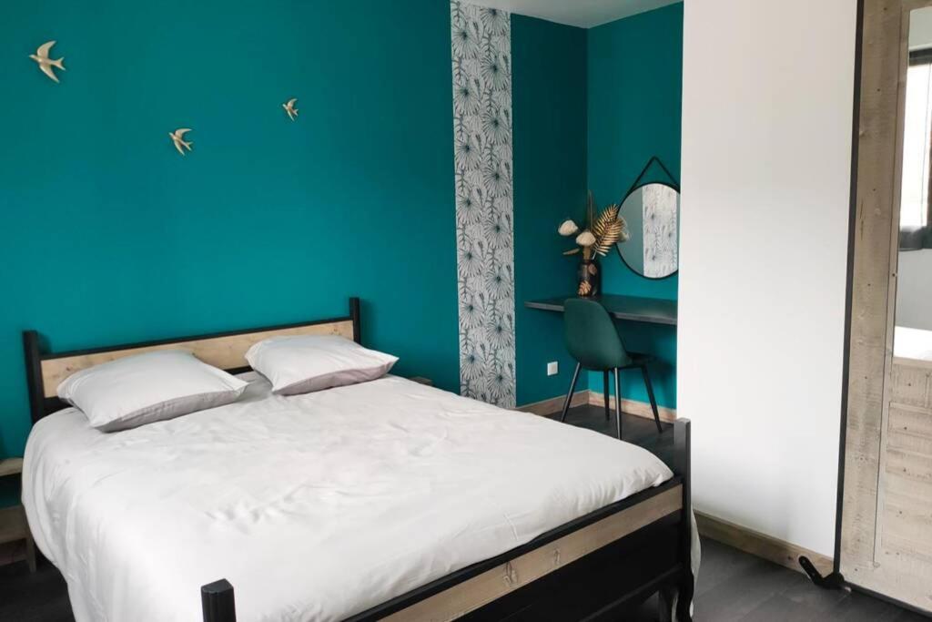 a bedroom with a blue wall and a bed at Appartement cosy proche de la gare in Saint-Jean-de-Maurienne